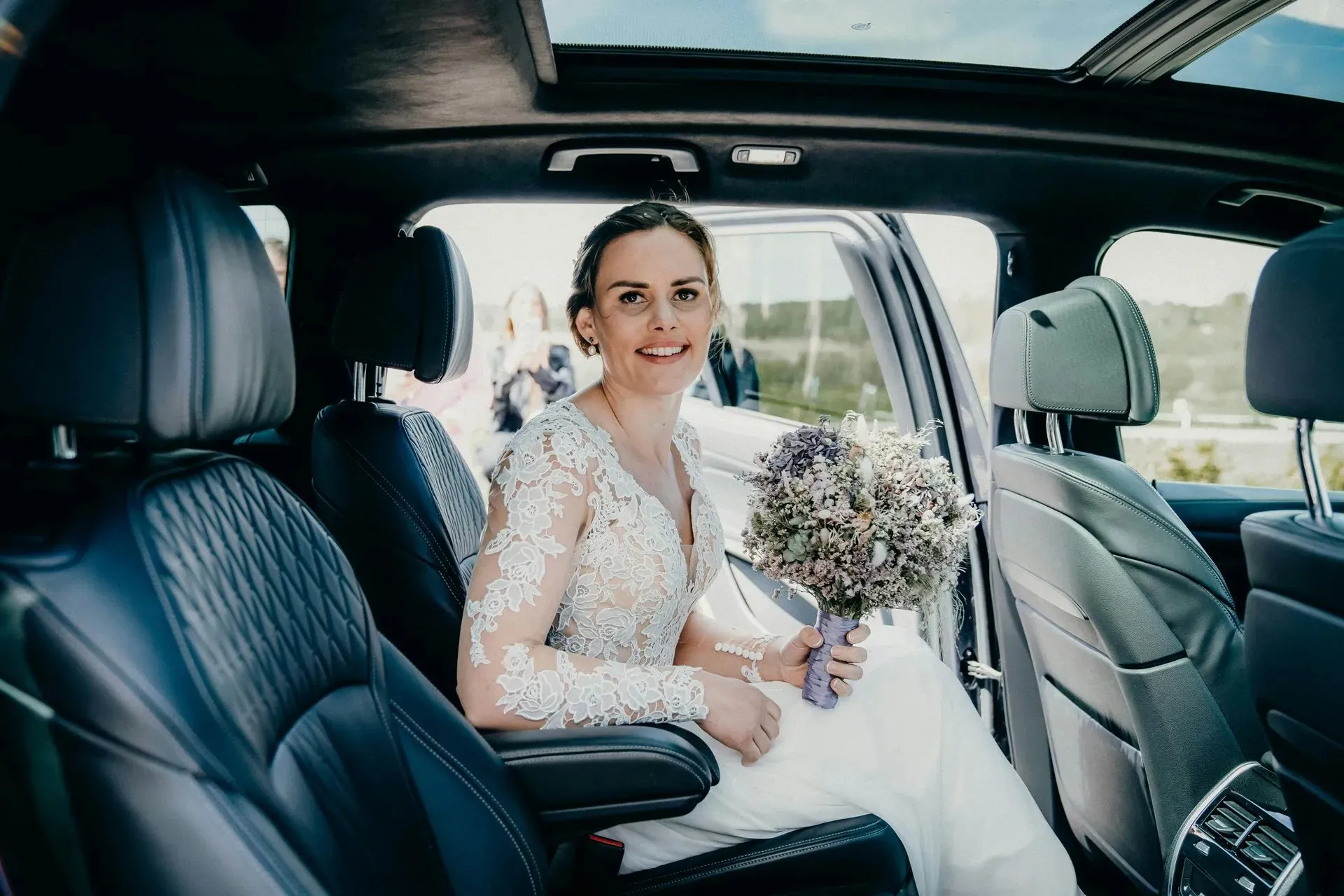 Bride with her bouquet seated in a black SUV for wedding shuttle service in Cleveland, OH